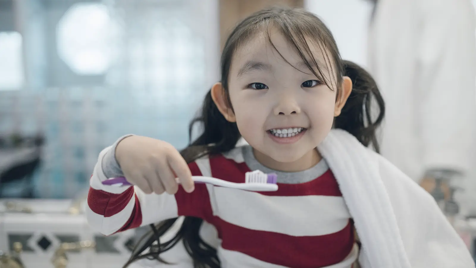집에서 칫솔을 들고 웃는 아이